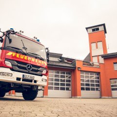 Feuerwehrauto, im Hintergrund Feuerwehrstützpunkt in Helsa